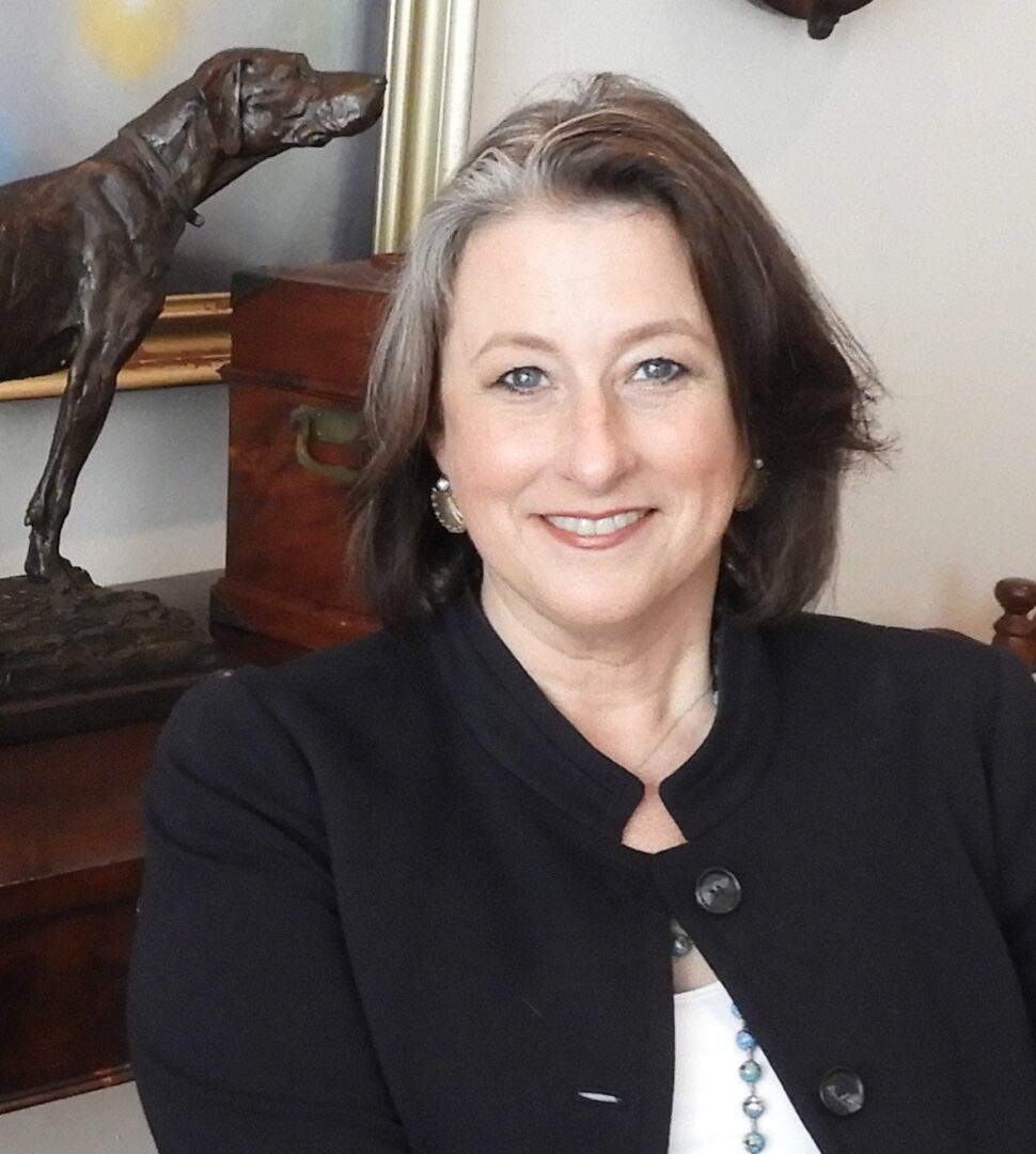 Image of a woman with a dog statue in the background