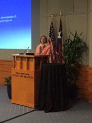 A woman speaking on a podium at a meeting