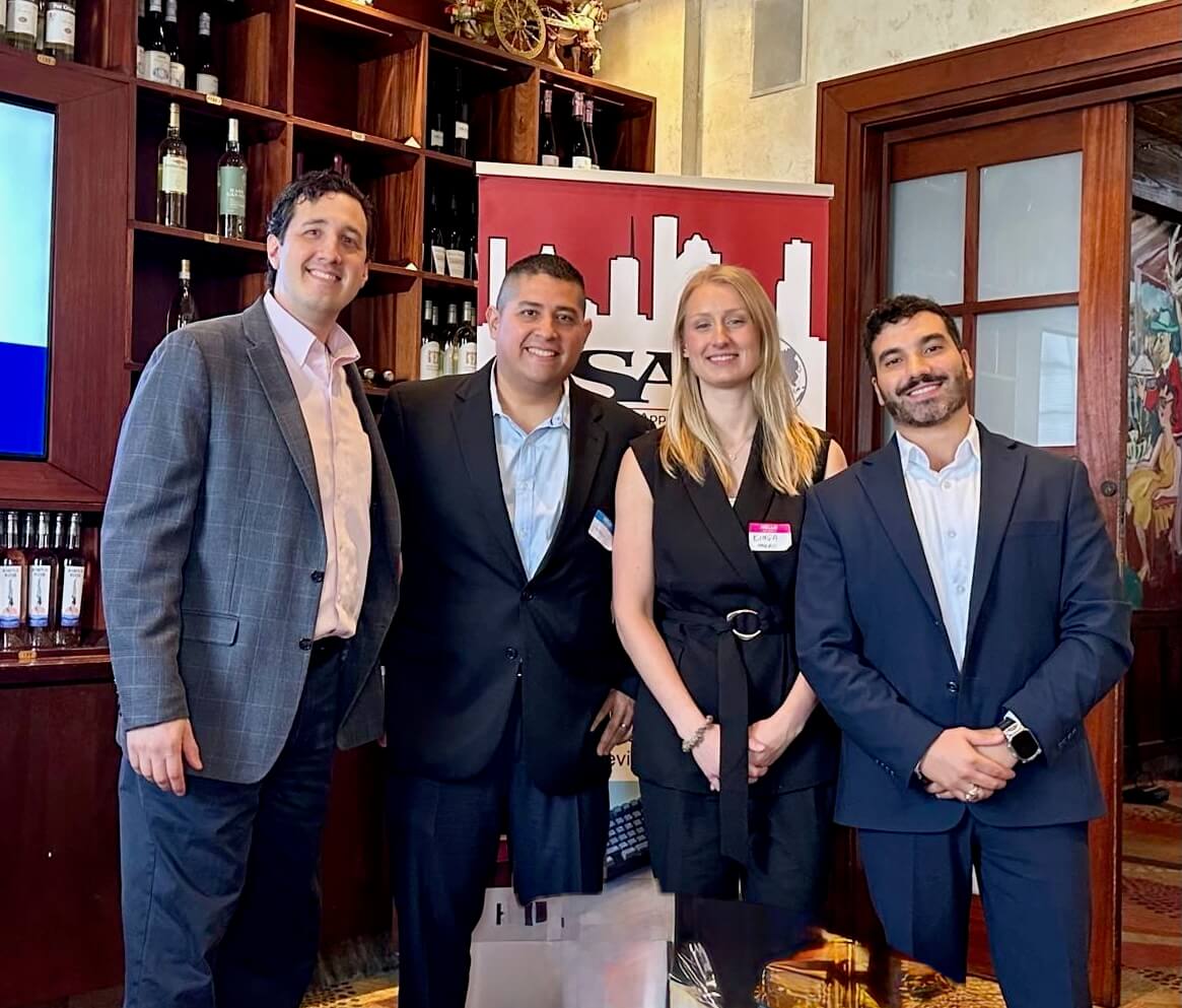 Four people posing at a professional event.
