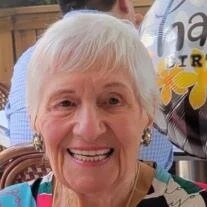 Smiling elderly woman with short white hair.